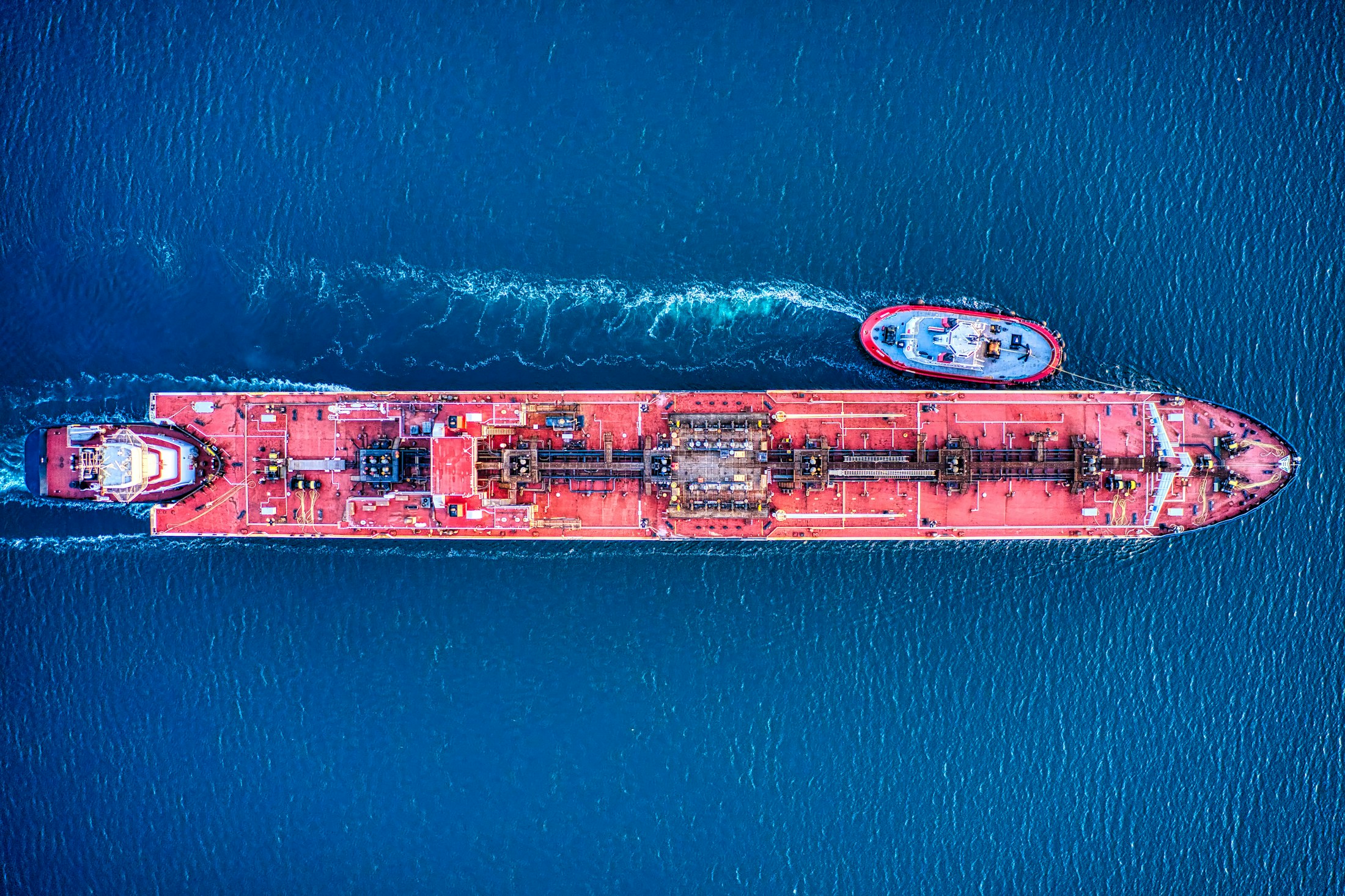Red tanker viewed from above on deep blue water